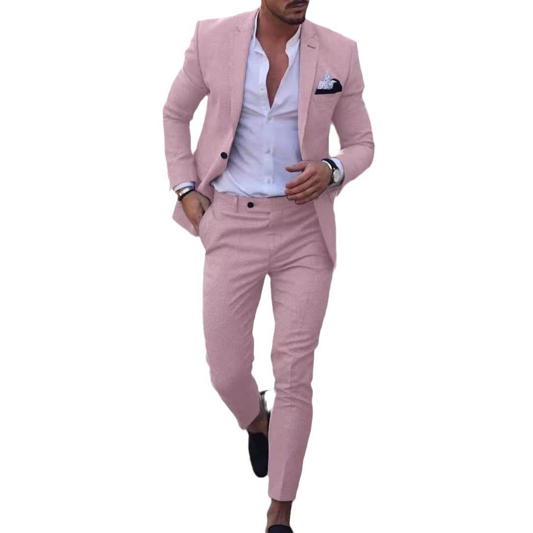A man wears a slim-fit, single-breasted light pink suit with a white shirt and pocket square.