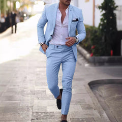 A man wears a light blue slim-fit suit with a white button-down shirt and black loafers.