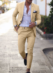 A man wears a slim-fit beige suit with a white shirt and black loafers.