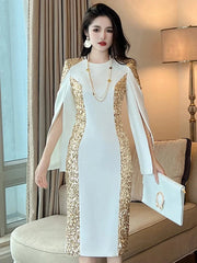 A woman wears a white knee-length pencil dress with gold sequin side panels and cloak sleeves.