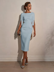 A woman wears a light blue midi-length bodycon dress with half sleeves and pearl-trimmed slits.