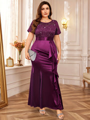 A plus-size purple floor-length dress with a sequined lace bodice and a ruffled mermaid hem.