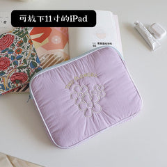 A light purple quilted tablet sleeve featuring embroidered flower designs and the text Two Flowers.