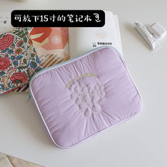 A light purple, rectangular, padded laptop sleeve featuring embroidered flower designs and the text Two Flowers.