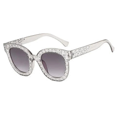 Clear cat-eye sunglasses with star-shaped embellishments and gradient lenses.