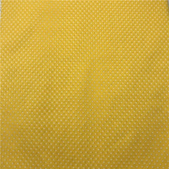 A close-up view of yellow fabric featuring a repeating pattern of small white dots.