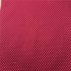 A close-up of fabric featuring a repeating pattern of small white dots on a deep red background.