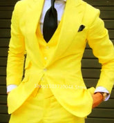 A man wears a bright yellow three-piece suit with a white shirt and a black polka-dot tie.