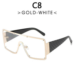 Oversized square sunglasses with a gold metal frame and a single clear lens.