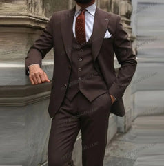 A man wears a formal three-piece brown suit consisting of a blazer, vest, and matching trousers.