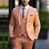 A man wears a formal three-piece orange suit consisting of a blazer, vest, and trousers.