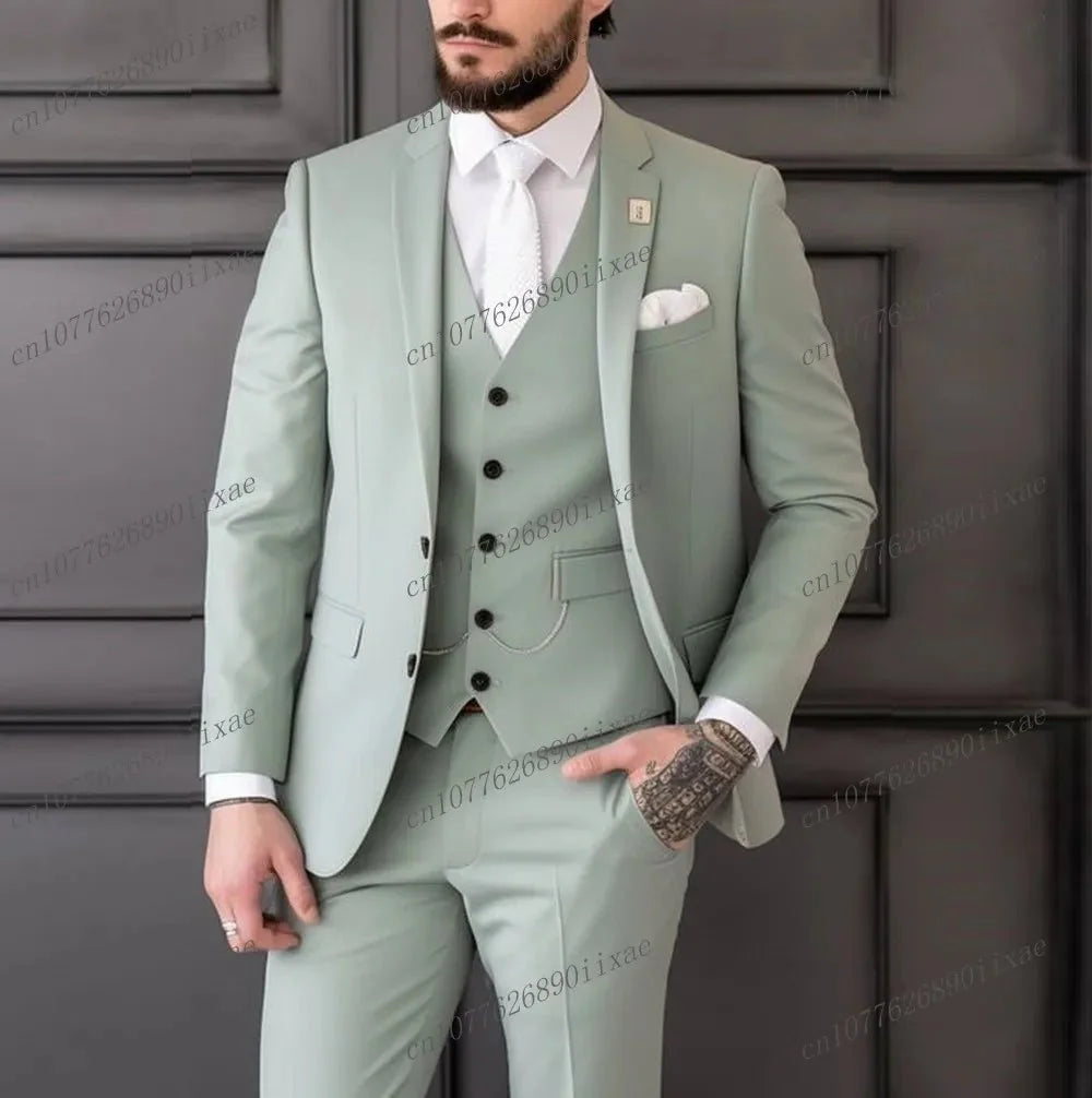A man wears a light green three-piece suit consisting of a blazer, vest, and matching trousers.