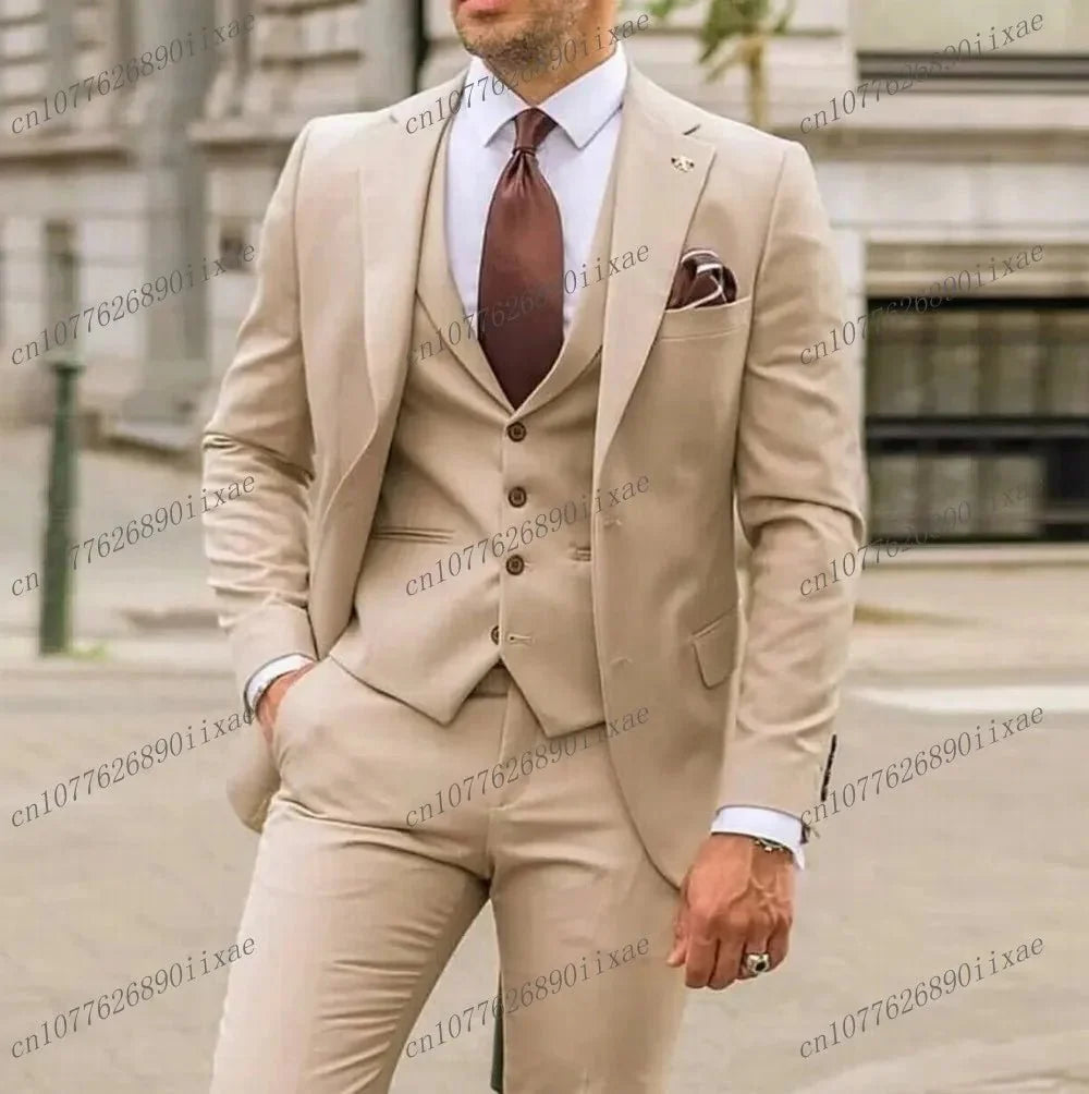 A man wears a formal three-piece beige suit consisting of a blazer, vest, and trousers.