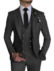 A man wears a charcoal grey three-piece suit with a peak lapel, white shirt, and black tie.