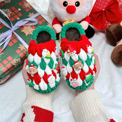 A pair of handmade, chunky crochet Christmas slippers decorated with festive charms.