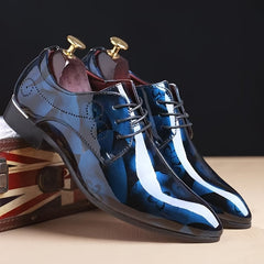 A pair of men's blue floral pattern pointed-toe faux leather oxford dress shoes with lace-up fronts.
