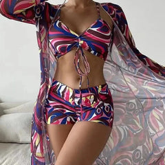 A woman wears a colorful patterned tankini set with a matching sheer long-sleeved cover-up.