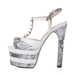 White and snakeskin print platform sandals with a chunky heel, T-strap, and metal rivets.