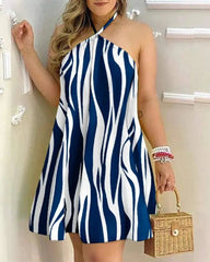 A woman wears a blue and white zebra-print halter neck mini dress with a flared silhouette.