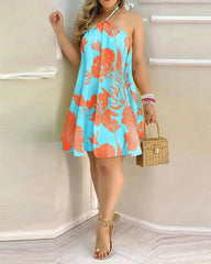 A woman wears a light blue mini dress with an orange floral print and a halter neckline.