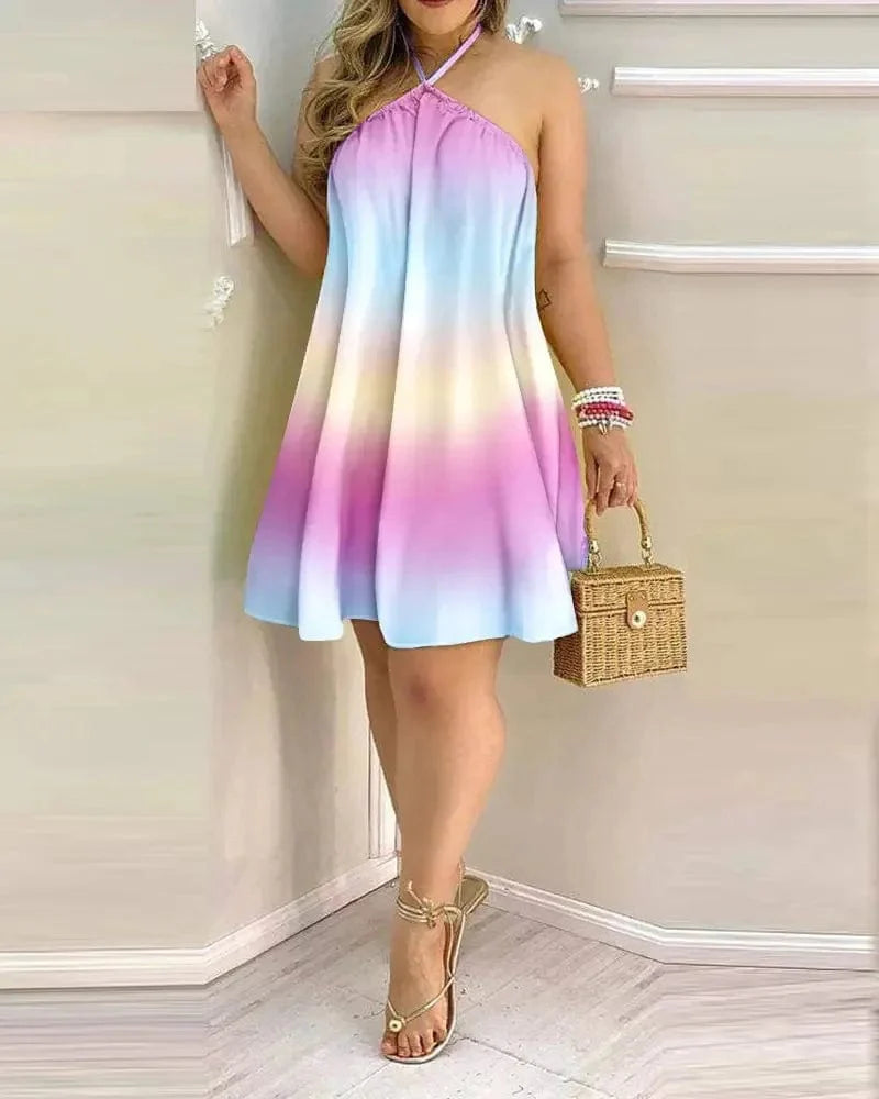 A woman wears a pastel ombre halter neck mini dress with a flared silhouette.