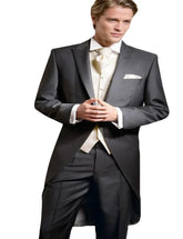 A man wears a formal black three-piece swallow-tailed suit with a cream vest and white cravat.