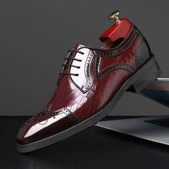 A burgundy wing-tip brogue dress shoe with a glossy crocodile-embossed finish and lace-up closure.