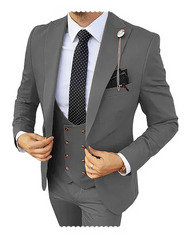 A man wears a grey three-piece suit with a white shirt, polka dot tie, and a decorative lapel pin.
