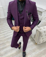 A man wearing a slim-fit purple three-piece suit with a black shirt and tie.