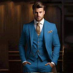 A man wears a slim-fit blue three-piece suit with a textured gold tie and pocket square.