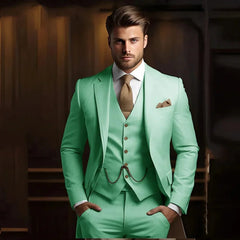 A man wears a slim-fit, three-piece mint green suit with a textured brown tie and pocket square.