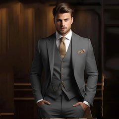 A man wears a slim-fit grey three-piece suit with a textured gold tie and pocket square.