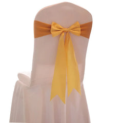 A white chair cover decorated with a bright yellow satin ribbon tied in a bow on the back.