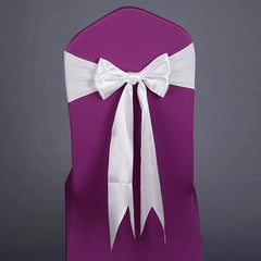 A purple chair cover featuring a white satin ribbon tied in a bow on the back.