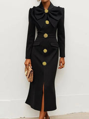 A black ankle-length dress with a large bow neckline, gold buttons, and a front slit.