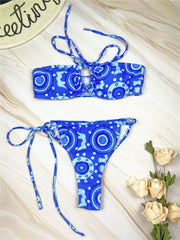 A blue bikini set with a circular pattern, featuring a lace-up halter top and tie-side bottoms.