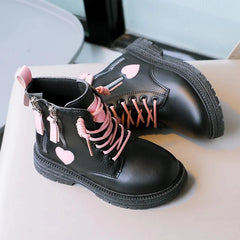 Black ankle boots for girls featuring pink laces, side zippers, and pink heart accents.
