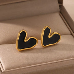A pair of gold-tone stainless steel stud earrings featuring a black heart-shaped design.