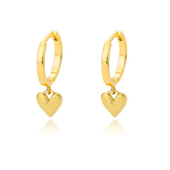 A pair of gold-colored stainless steel hoop earrings featuring a dangling heart-shaped charm.