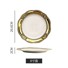 An eight-inch round ceramic plate featuring a white ribbed center and an ornate gold-trimmed rim.