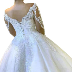 A white ball gown wedding dress featuring a V-neckline, long lace sleeves, and lace appliques.