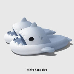 A pair of light blue and white gradient shark-shaped slide sandals with thick soles.