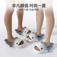 Two pairs of gradient shark-shaped EVA slides with thick soles are shown on feet.