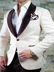 A man wears a white patterned tuxedo jacket with a dark brown shawl lapel and matching pocket square.