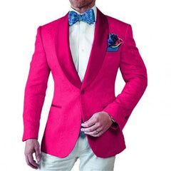 A man wears a bright pink patterned tuxedo jacket with a satin shawl lapel and a blue bow tie.