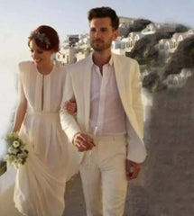 A man wears a white two-piece suit with a shawl satin lapel while walking with a bride.
