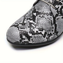 A close-up of a gray and black snake-patterned oxford shoe with a pointed toe and lace-up closure.