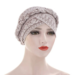 A beige cotton turban hijab for women featuring a braided headband and a patterned print.