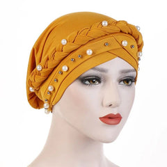 A mustard yellow cotton turban hijab decorated with a braided band and scattered white pearls.