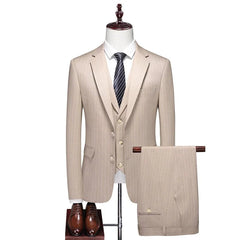 A beige pinstriped three-piece suit featuring a blazer, vest, and trousers with brown dress shoes.